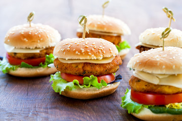 Wall Mural - Appetizing mini chicken burgers on wooden surface.