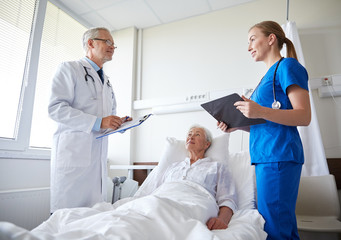 doctor and nurse visiting senior woman at hospital