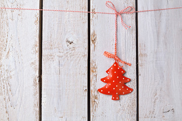 Christmas tree ornament hanging over white wooden background