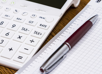 A calculator and a pen on desk