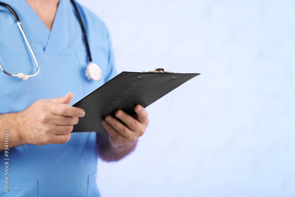 Doctor with clipboard on light blue background