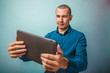 © maxximmm - a man of European appearance thirty years looking at tablet smil