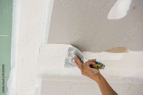 Man Hand With Trowel Plastering A Ceiling Skim Coating Plaster