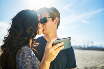 Wall Mural - couple kissing while taking selfie together