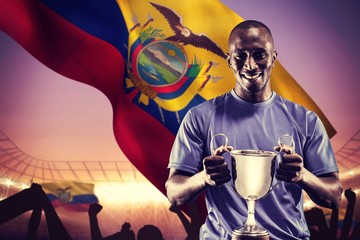 Composite image of portrait of happy athlete holding trophy