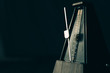 Vintage metronome, on a dark background.