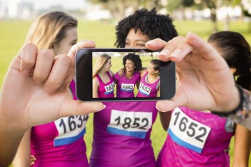 Wall Mural - Composite image of hand holding smartphone showing