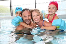 Portrait Of Family Having Fun In Public Indoor Swimming-pool