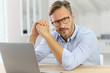 © goodluz - Handsome 40-year-old man at home using laptop