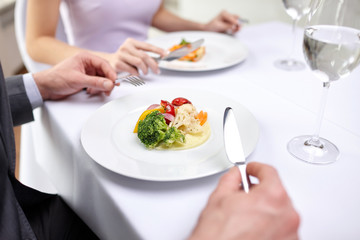 close up of couple eating appetizers at restaurant