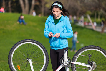 Sad woman fixing bike