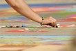 Madonnari- Street art with chalk, woman hand woman hand