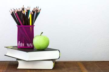 green apple with pencil box on wooden table in concept of study