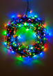 Colorful Christmas lights wreath - A multicolor Christmas wreath created by a set of wired lights arranged in a circular pattern and shot in low light for vibrant colors.