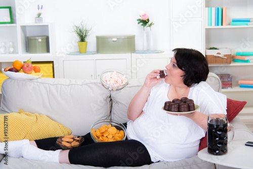 Fototapete Dicke Frau Isst Schaumküsse Auf Dem Sofa - Fototapeten-Racle  Fotodesign