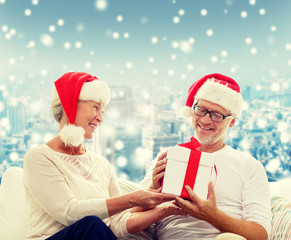 Canvas Print - happy senior couple in santa hats with gift box