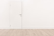 White door and a light brown hardwood floor