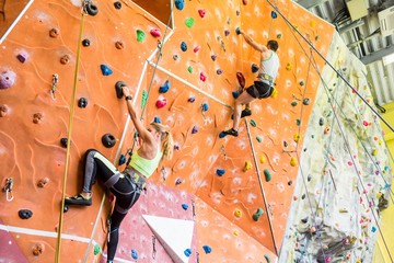 Wall Mural - Fit couple rock climbing indoors 