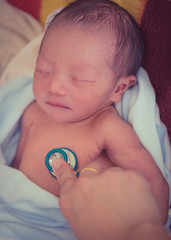 Close-up shot of pediatrician examines 1 day baby girl. Doctor using a stethoscope to listen to baby's chest checking heart beat