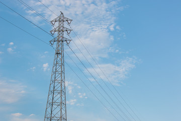 Mast electrical power line against cloud and blue sky.