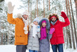 © Syda Productions - group of friends waving hands in winter forest