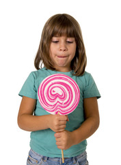 4 or 5 years old child girl eating big pink lollipop candy isolated on white background