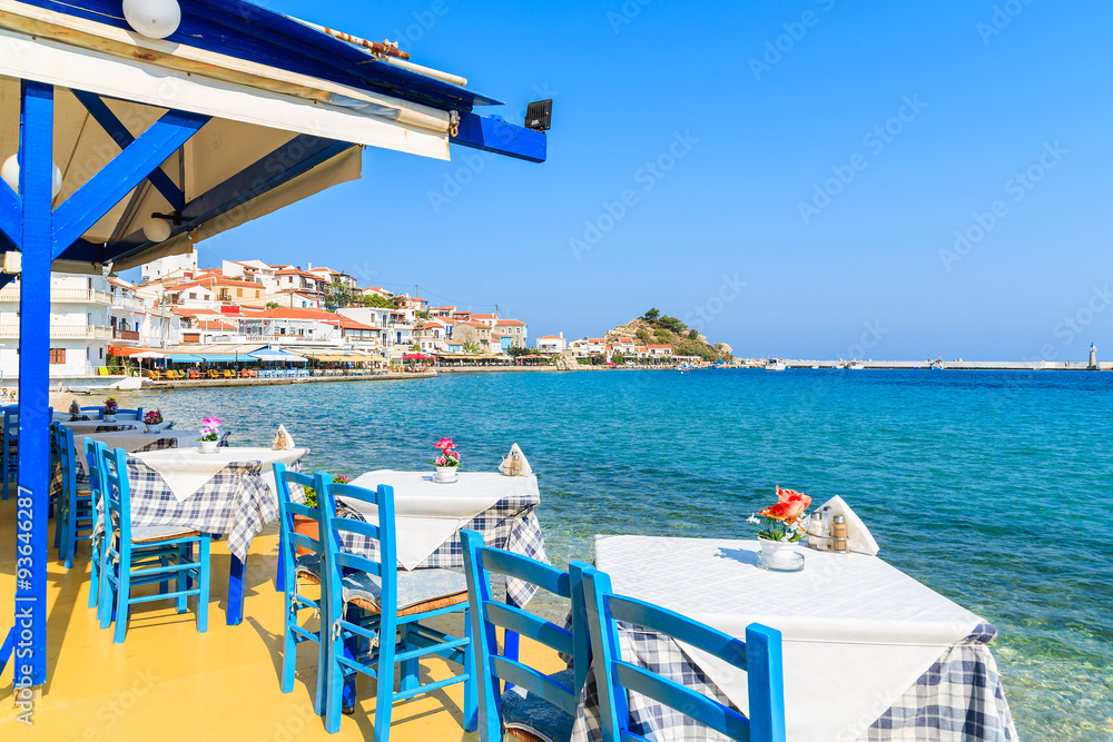 Obraz na płótnie Tables with chairs in traditional Greek tavern in Kokkari town on coast of Samos island, Greece w salonie