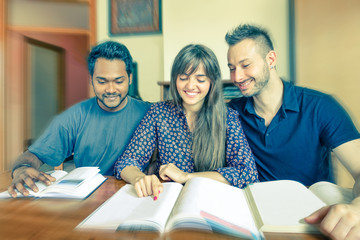 Wall Mural - Group of multiracial students reading books home - Young business people doing teamwork - Multiethnic concept of social interaction and joy - Vintage filtered look with radial zoom defocus
