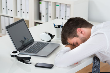 Businessman With Laptop Sleeping At Desk