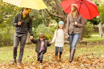 Wall Mural - Smiling young family under umbrella