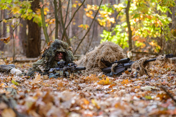 Two snipers on position in  forest/Two masked sniper in position for firing in the forest