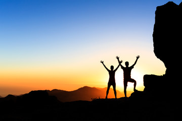 Wall Mural - couple hikers success concept in mountains