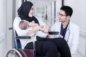 Poster - Physician speaking with young mother in hospital