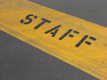 Yellow Staff Sign On Parking Lot Pavement