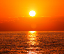 Sunset With Orange Sun And Glittering Water