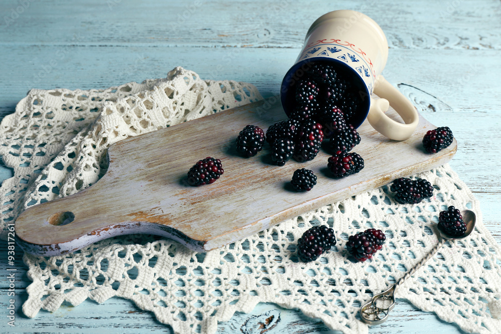 Heap of sweet blackberries in cup on table close up