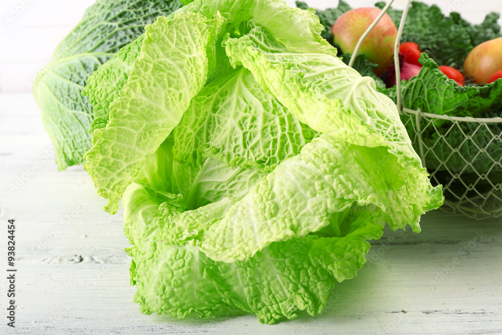 Savoy cabbage and other vegetables on wooden background