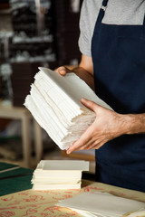 Wall Mural - Male Worker Holding Stacked Papers At Table