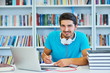 © blicsejo - happy young man study in the library with his laptop