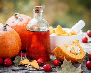 Wall Mural - pumpkin seeds oil bottle, pumpkins, hawthorn berries and mortar