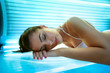 young woman laying on solarium bed