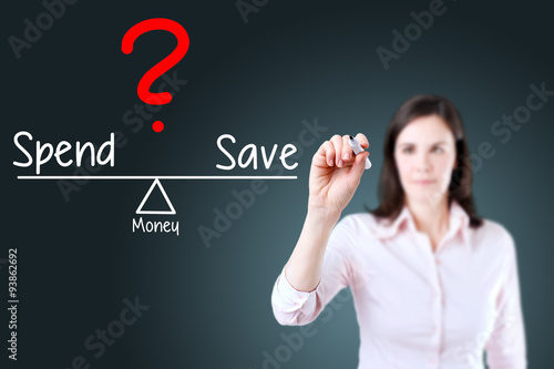 Fotografía Young business woman writing spend and save compare on balance bar