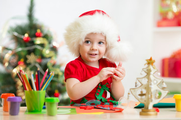 child girl making by hands christmas decorations