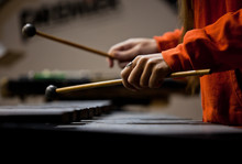 Hands Of The Girl Playing The Xylophone In Dark Colors