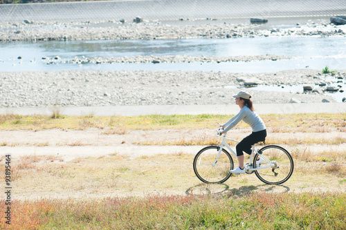 河川敷で自転車に乗っている日本人女性 Stock Photo Adobe Stock