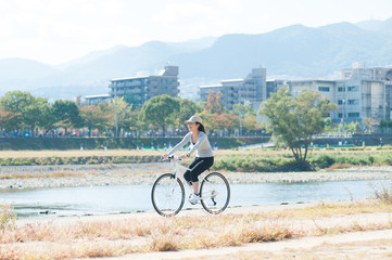 Wall Mural - 河川敷で自転車に乗っている日本人女性