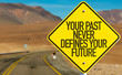 Your Past Never Defines Your Future sign on desert road
