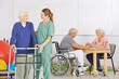 Krankenpflegerin mit Senioren im Pflegeheim