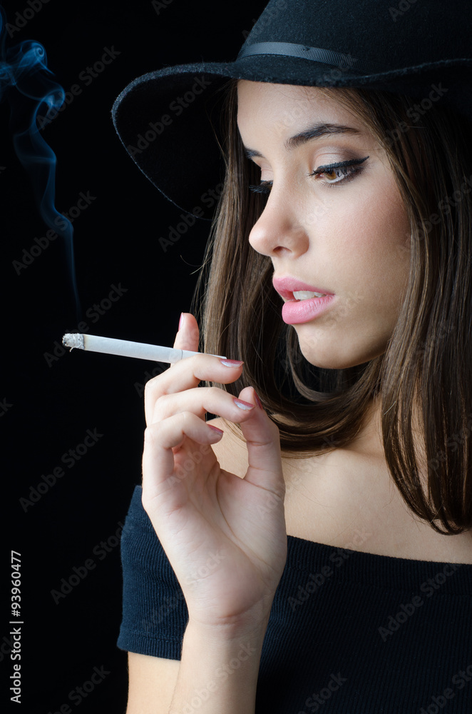 Portrait of the beautiful elegant girl smoking cigarette isolated on black  Stock Photo