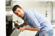 © Fotos 593 - Hispanic male wearing blue shirt in modern kitchen leaning